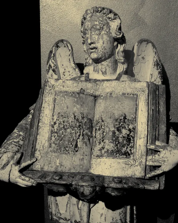 An angel holding an open Bible